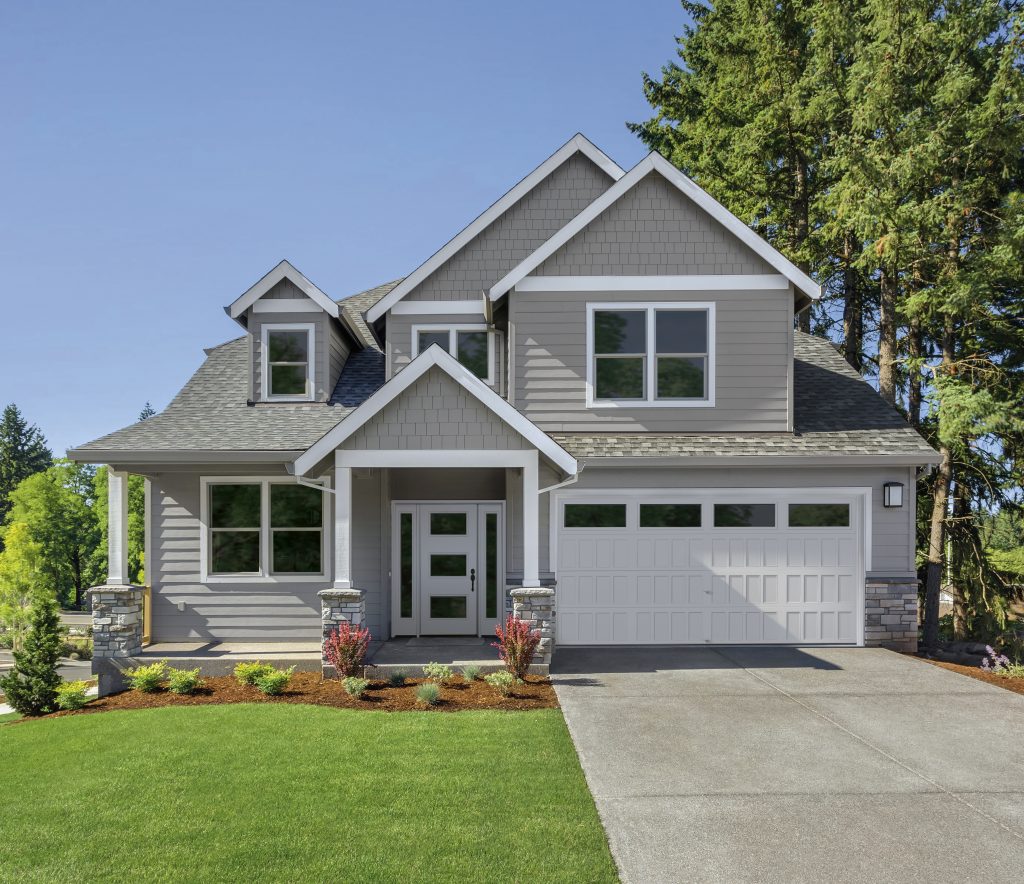 Gray house with white garage door and green lawn
